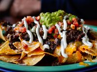 Beef and cheese corn nachos served on a big plate ready to eat, mexican food